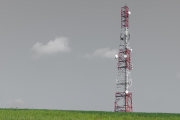 Communication tower on field hill with clear sky