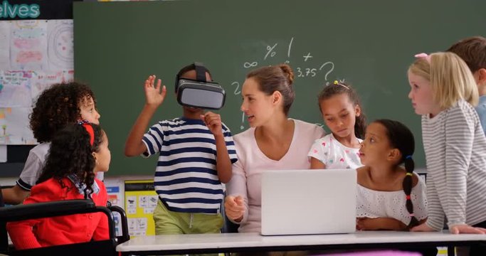 Front view of African american schoolboy using virtual reality headset with teacher and classmates i