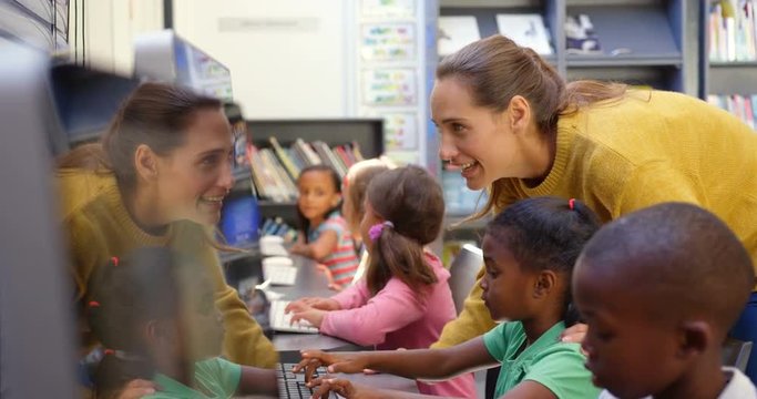 Side view of mixed-race schoolkids studying on computer in the classroom 4k