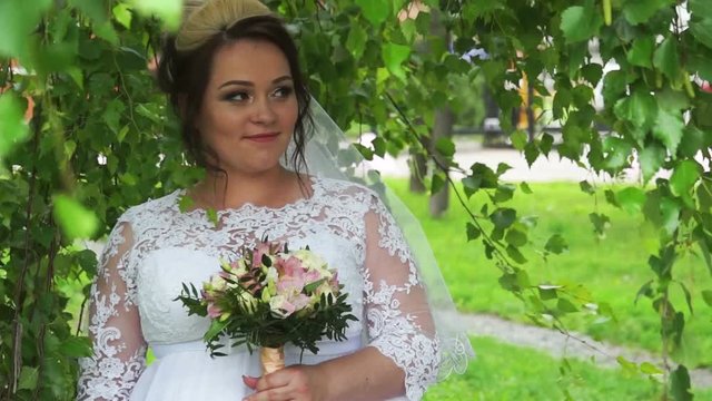 Bride posing under a tree