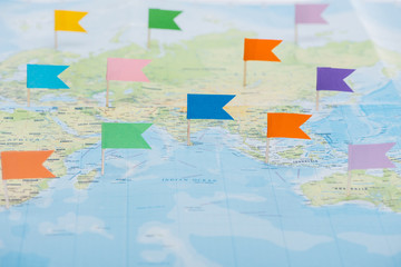 Fototapeta na wymiar colorful stationery flags pinned on world map