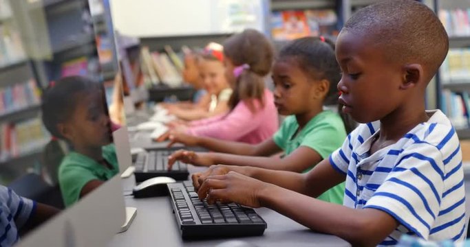 Side view of mixed-race schoolkids studying on computer in the classroom 4k