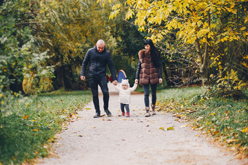 Fototapeta premium Cute family walking in a autumn park. Mother with little daughter