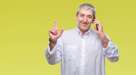 Handsome senior man talking on smartphone over isolated background surprised with an idea or question pointing finger with happy face, number one