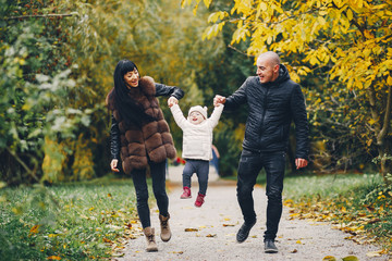 Naklejka premium Cute family walking in a autumn park. Mother with little daughter