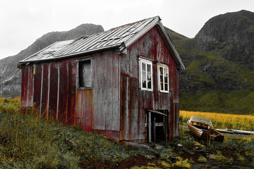 Fototapeta premium Old damaged and weathered wooden boat house at the coast of Vinstad on Lofoten Islands in Norway