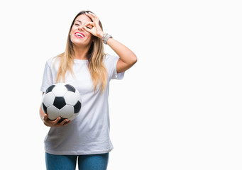 Young beautiful woman holding soccer ball over isolated background with happy face smiling doing ok sign with hand on eye looking through fingers