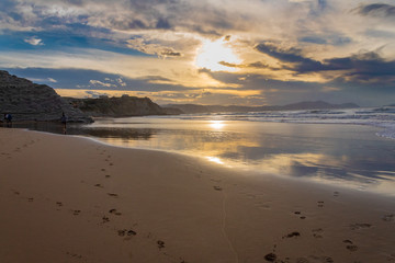 sunset on the beach of Atxabiribil, Sopelana, vizcaya. The sun is reflected on the seashore