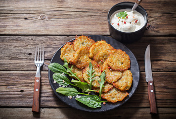 potato pancakes with sour cream on  wooden table