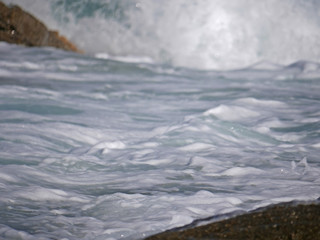 Fototapeta premium Waves crashing against the rock
