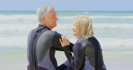 Rear view of active senior Caucasian couple interacting with each other on the beach 4k