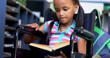Front view of disabled African American schoolgirl reading a book in library at school 4k - Powered by Adobe