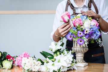 Arranging artificial flowers vest decoration at home, Young woman florist work making organizing...