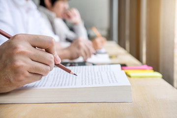 Education, teaching, learning, technology and people concept. Two high school students or classmates with helps friend do homeworks learning in classroom, Tutor books with friends