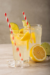 two glasses of lemonade with lemons and lime and straw, a cool drink and summer mood, with ice