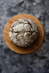 Rustic rye bread on monochrome concrete background top view