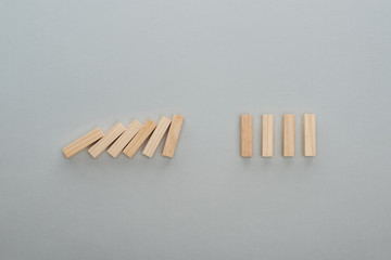 top view of falling wooden blocks isolated on grey, domino effect concept
