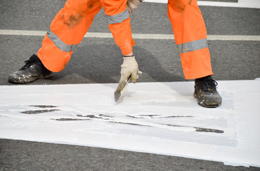 Road worker makes white paint