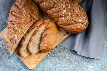 Cereal Bread Roll with various Seeds on a wooden cutting board. Top view