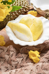 Fresh yellow durian fruit in a bowl and decorate with flowers. Sweet dessert concept