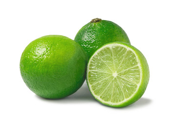 Fresh ripe limes, two whole and one half isolated on white background with shadow - image
