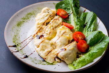 chicken chop with cheese and vegetables on a plate