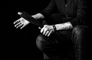 Strict man with paddle. BDSM concept.