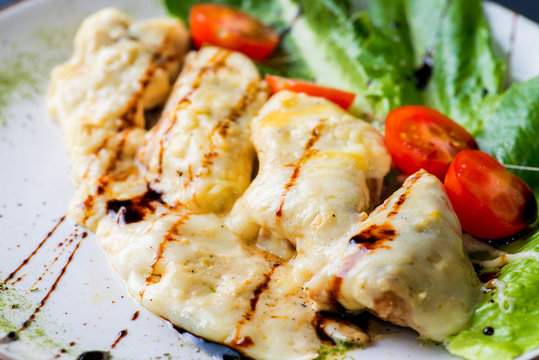 chicken chop with cheese and vegetables on a plate