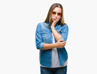 Young beautiful caucasian woman wearing sunglasses over isolated background thinking looking tired and bored with depression problems with crossed arms.