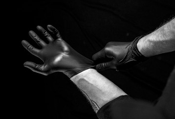 Man putting on latex gloves. BDSM concept.