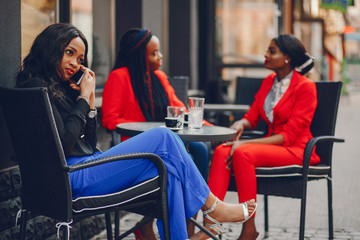 Elegant black woman standing in a summer city. Businesswoman talk at the table