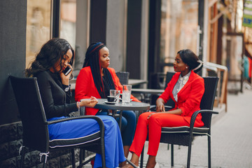 Elegant black woman standing in a summer city. Businesswoman talk at the table