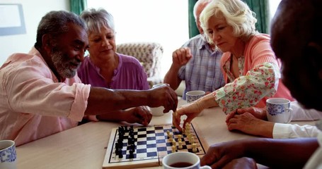 Active diverse senior people playing chess game in the nursing home 4k - Powered by Adobe