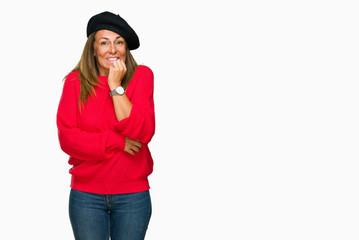 Middle age adult woman wearing fashion beret over isolated background looking stressed and nervous with hands on mouth biting nails. Anxiety problem.