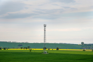 Mobile transmitter in countryside with cloudy sky.