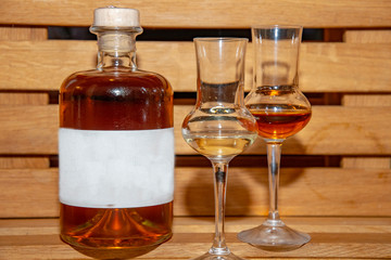 a full bottle of whiskey with two glasses and text space sign on the bottle