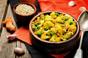 cauliflower green peas turmeric rice on a wood background