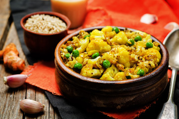 cauliflower green peas turmeric rice on a wood background
