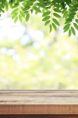 Naklejka na ściany i meble Wooden table and blurred green nature garden background.