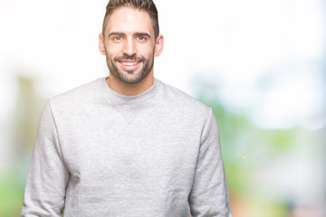 Young handsome man wearing sweatshirt over isolated background with a happy and cool smile on face. Lucky person.