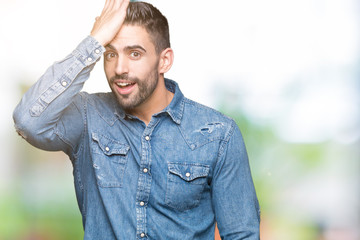 Young handsome man over isolated background surprised with hand on head for mistake, remember...