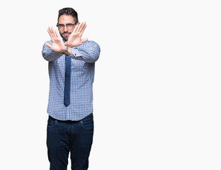 Fototapeta premium Young business man wearing glasses over isolated background Rejection expression crossing arms and palms doing negative sign, angry face