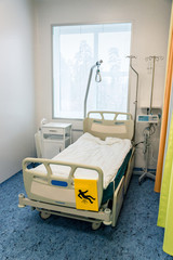 interior in a hospital, hospital bed with additional shelves and equipment in the room