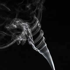 Abstract white smoke swirls pattern over the black background