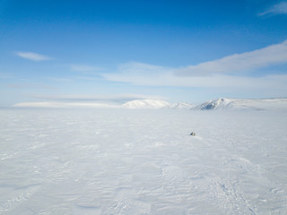 The car rides through the snow-covered Arctic Ocean. Aerial photography