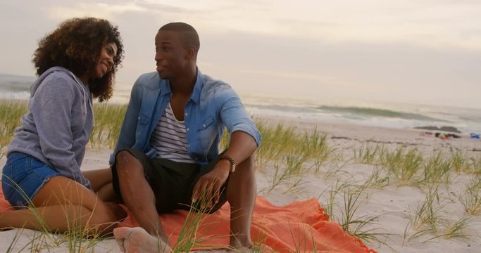 Front view of African american couple interacting each other on the beach 4k