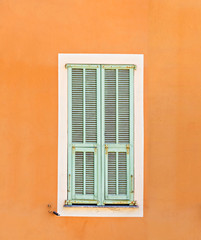 window with closed shutters on concrete wall