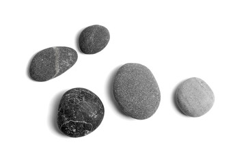 Scattered sea pebbles. Smooth gray and black stones isolated on white background. Top view