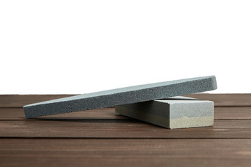Two grindstones. Oval and rectangular double layer sharpening stone. Whetstone sharpener on wooden table background