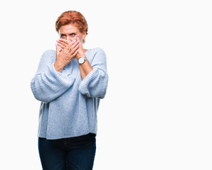 Atrractive senior caucasian redhead woman wearing winter sweater over isolated background shocked covering mouth with hands for mistake. Secret concept.
